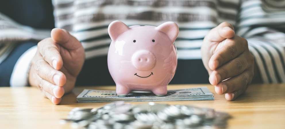Piggy bank with hands cupped around it