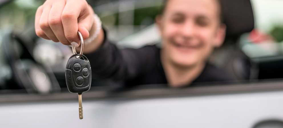 Person holding key through car window