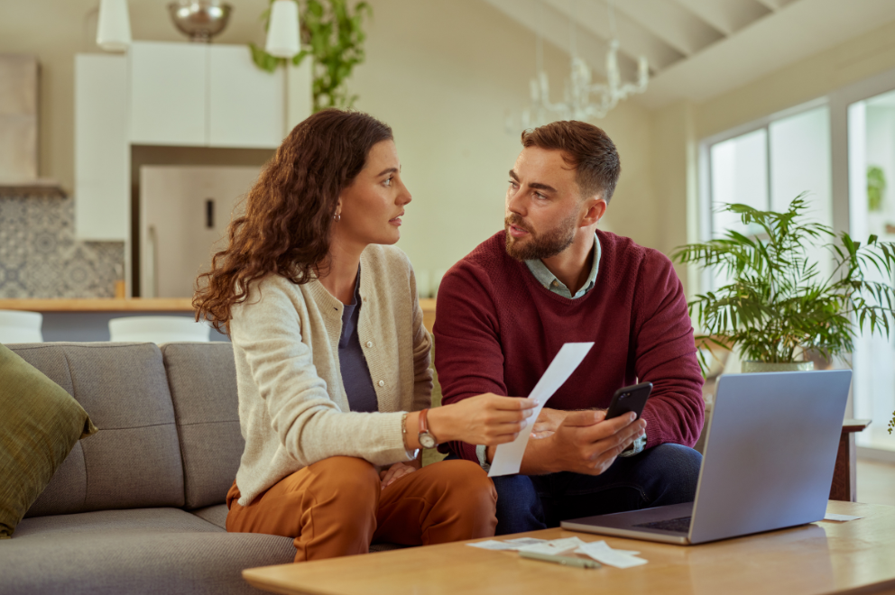 Man and woman in front of laptop and holding phone